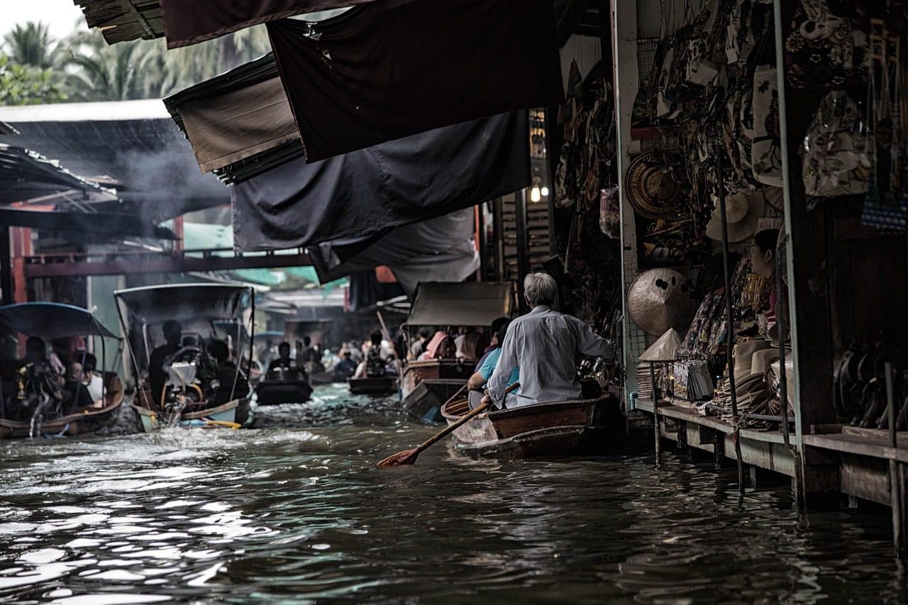 Boats moving along a covered canal at a floating market near Bangkok