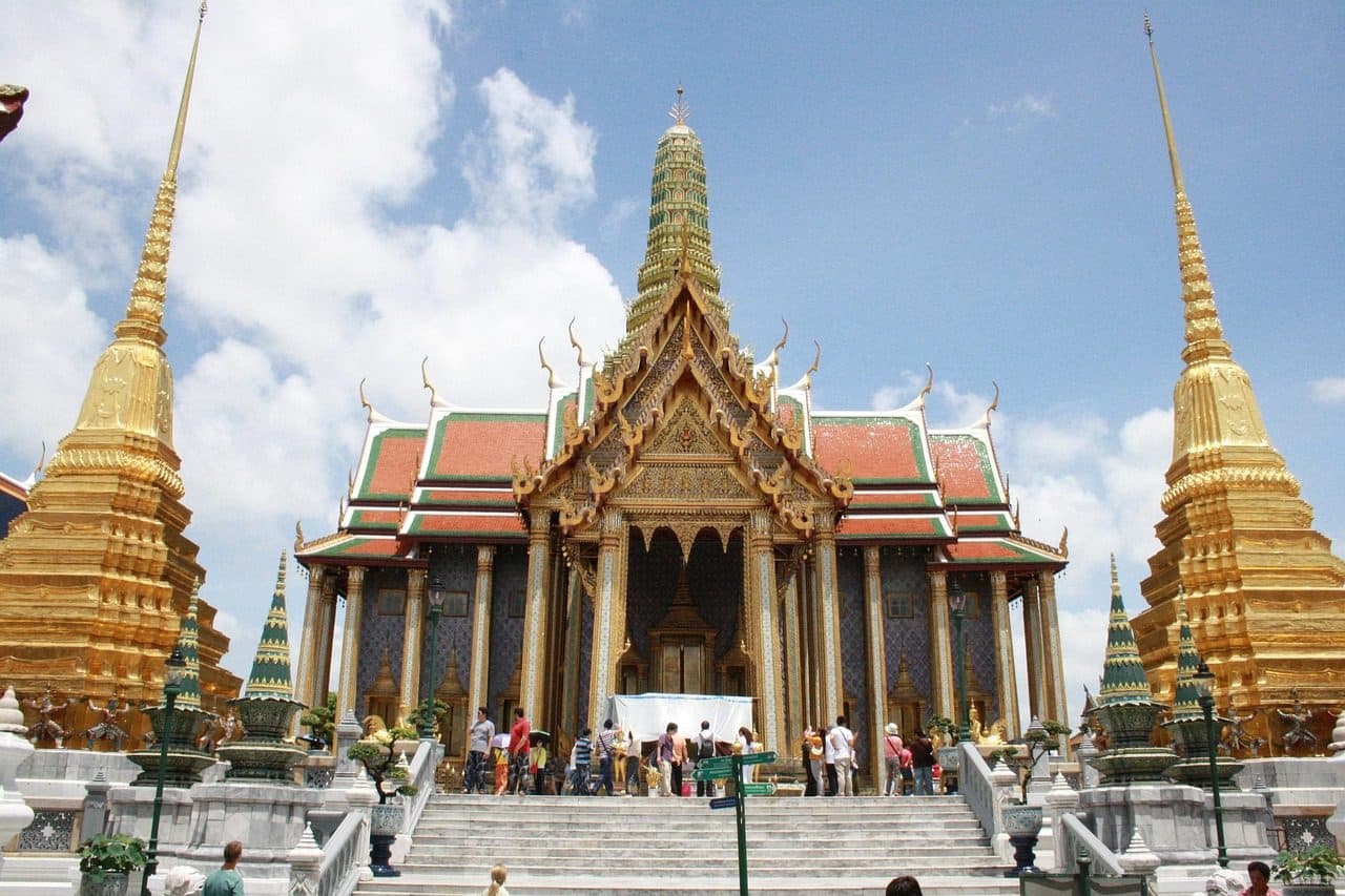 The ordination hall of Wat Phra Kaew, flanked by gilded chedis, inside the Grand Palace compound