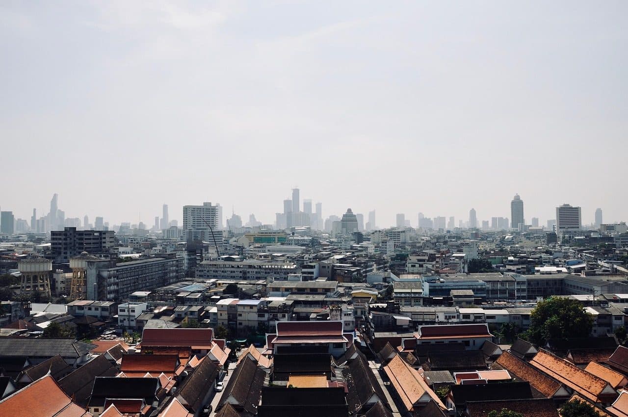 Old low-rise rooftops in the foreground and downtown towers on the horizon