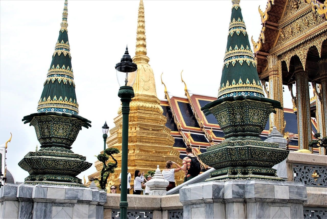 Gilded and green-tiled temple spires against a clear blue sky